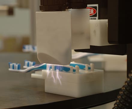 blown-arc-treating-toothbrushes Enercon's Blown Arc Series prepares the surfaces for printing.